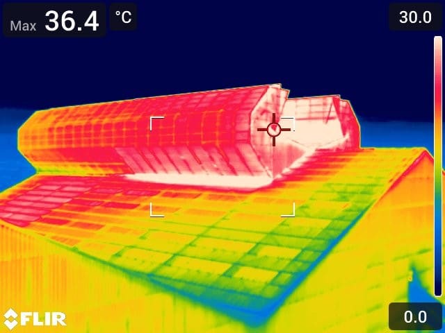 Photographie thermographique infrarouge d'un aérateur statique d'une usine utilisant la ventilation naturelle, avec des indications de température.