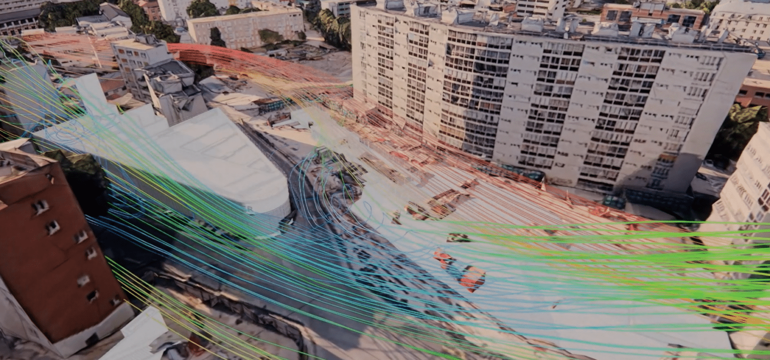 Simulação CFD – linhas de corrente de ar sobrepostas a uma vista aérea exterior do estaleiro da estação RER de Issy, com edifícios residenciais circundantes